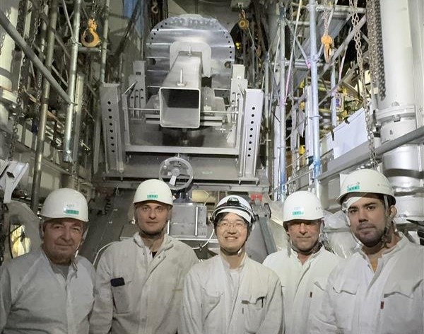 European and Japanese colleagues in front of the ETS structure, installed onto the tokamak.