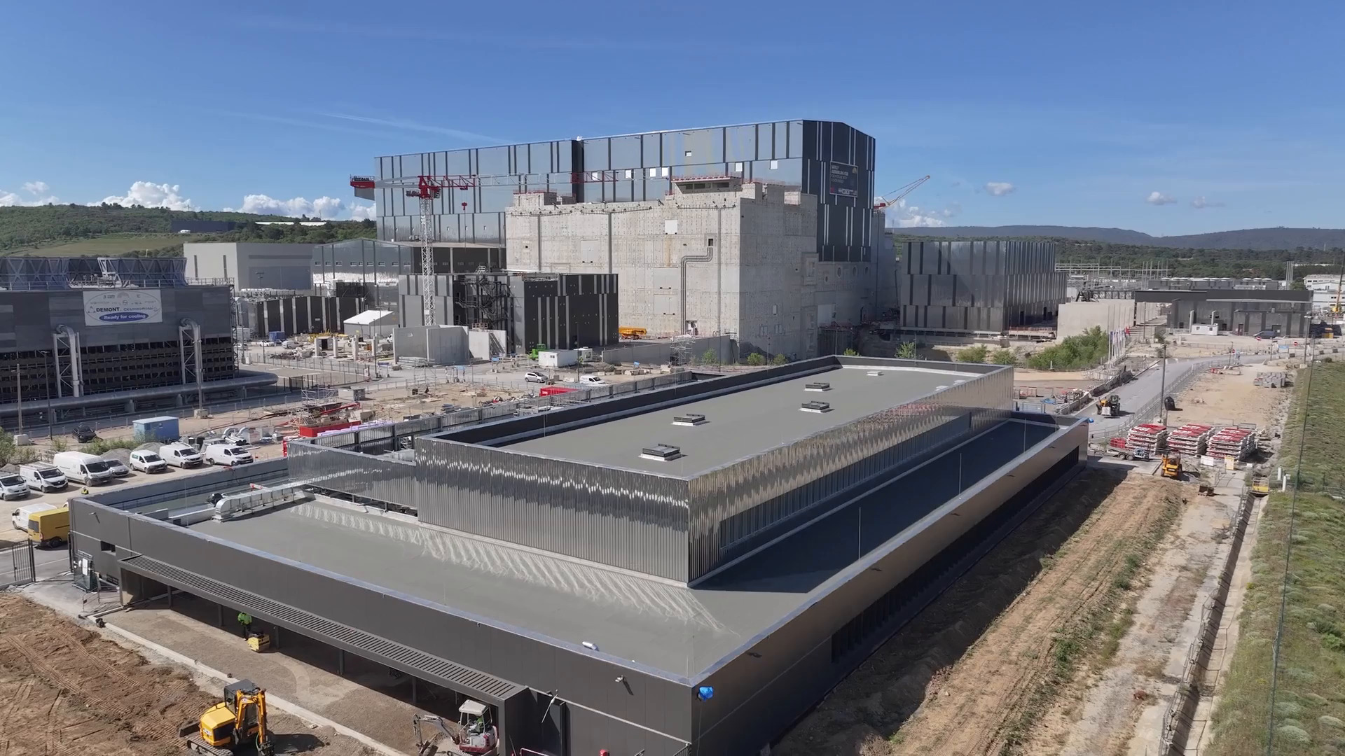 The ITER Control Building seen from a drone, during the last stage of works (May 2025), with the Tokamak Complex in the background. 