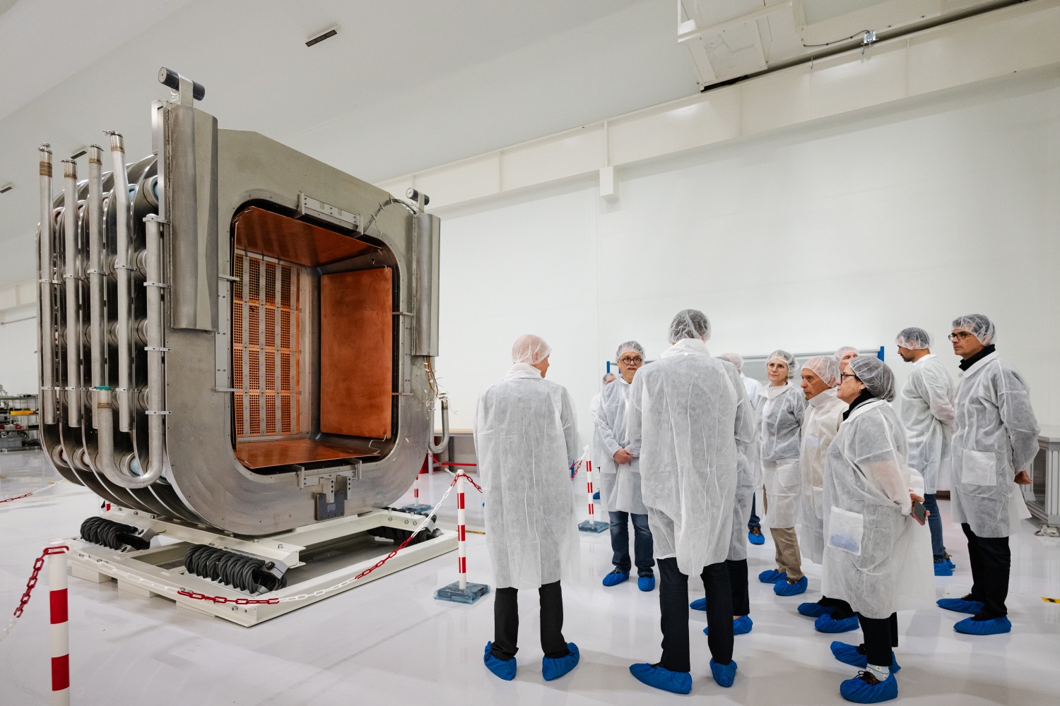 Participants in the ceremony speaking next to the MITICA beam source. ©ALSYMEX
